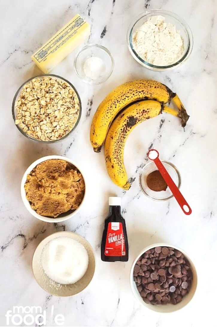 ingredients for banana oatmeal cookie recipe; ripe bananas with brown flecked banana peels, old fashioned oats, etc