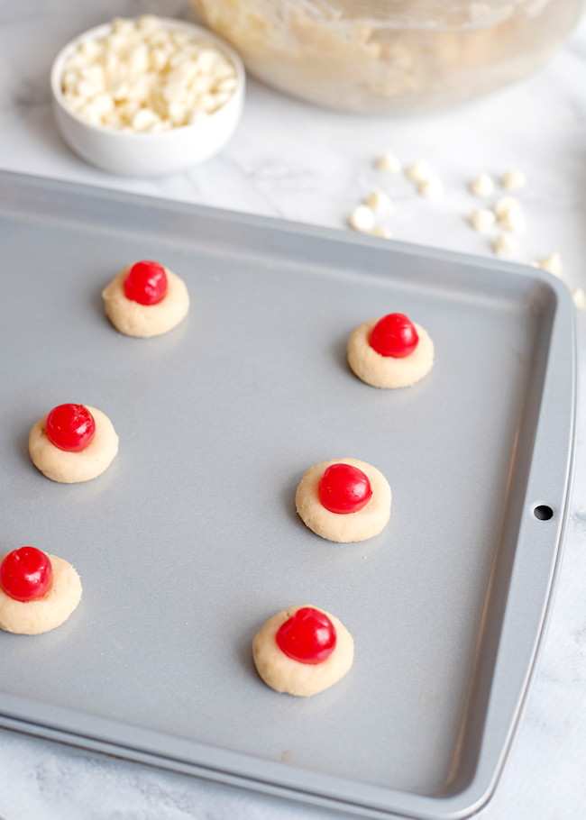 maraschino cherries on top of cookies and ready to bake.