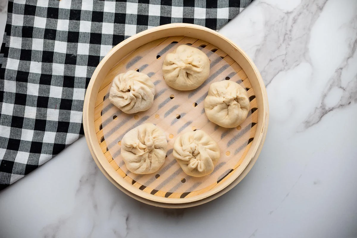 placing buns in bamboo steamer