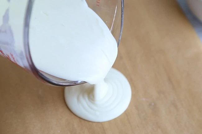 pouring white chocolate bark on parchment