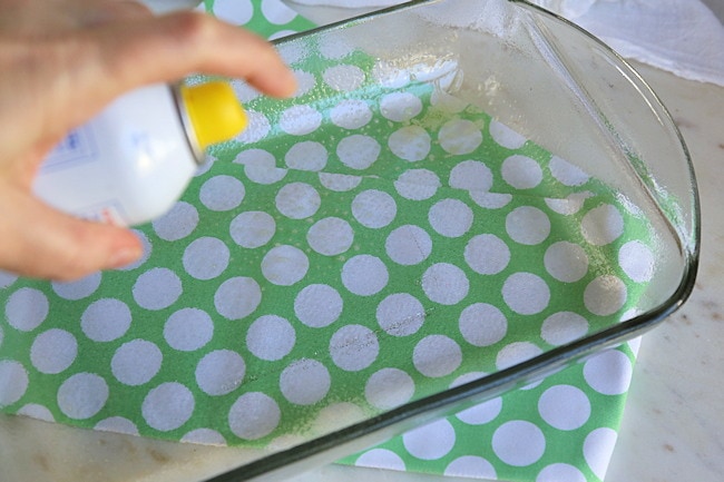 Preparing baking dish by coating with cooking spray.