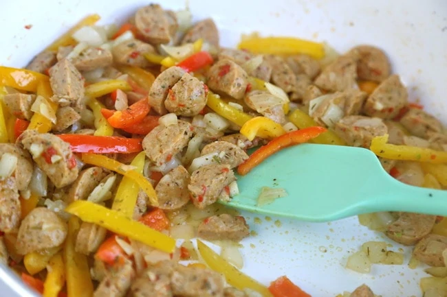 sauteing sausage and peppers with onions and herbs.