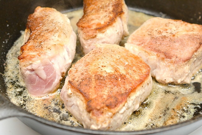 Searing  pork chops in cast iron skillet.