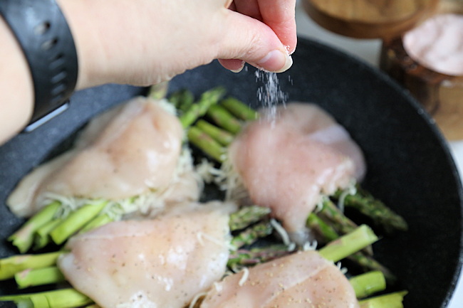 seasoning stuffed chicken with asparagus with salt and pepper