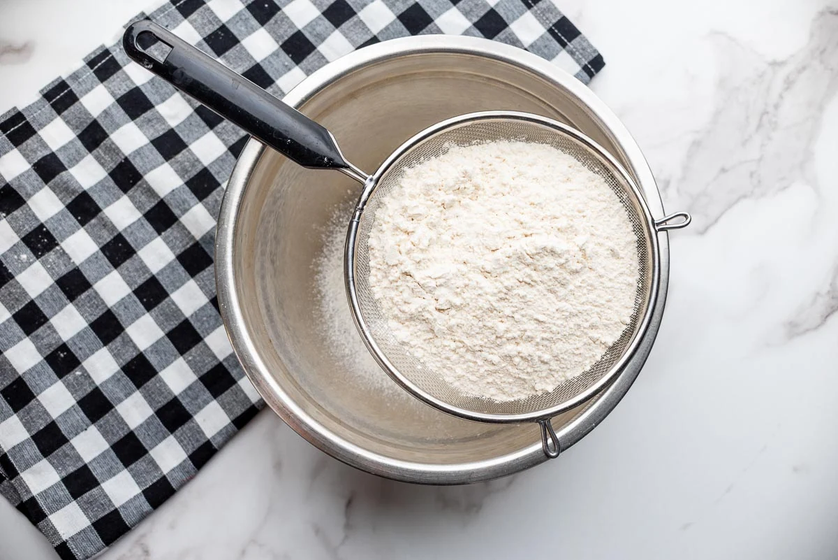 sifting flour into mixing bowl.