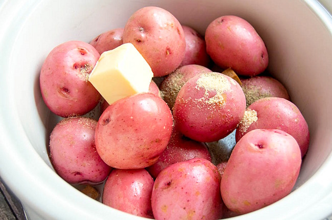 red potatoes in a slow cooker with butter and spices